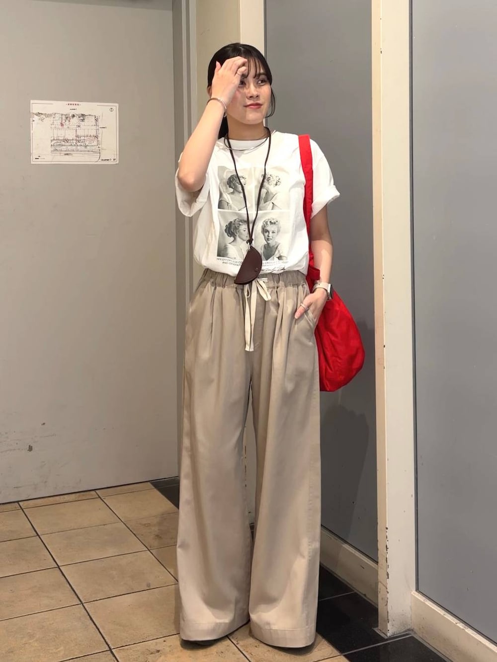 ベージュ系のデニムパンツ、レッド系のショルダーバッグ、ホワイト系のTシャツ/カットソーを着用したレディースの春コーディネートの5枚目の写真