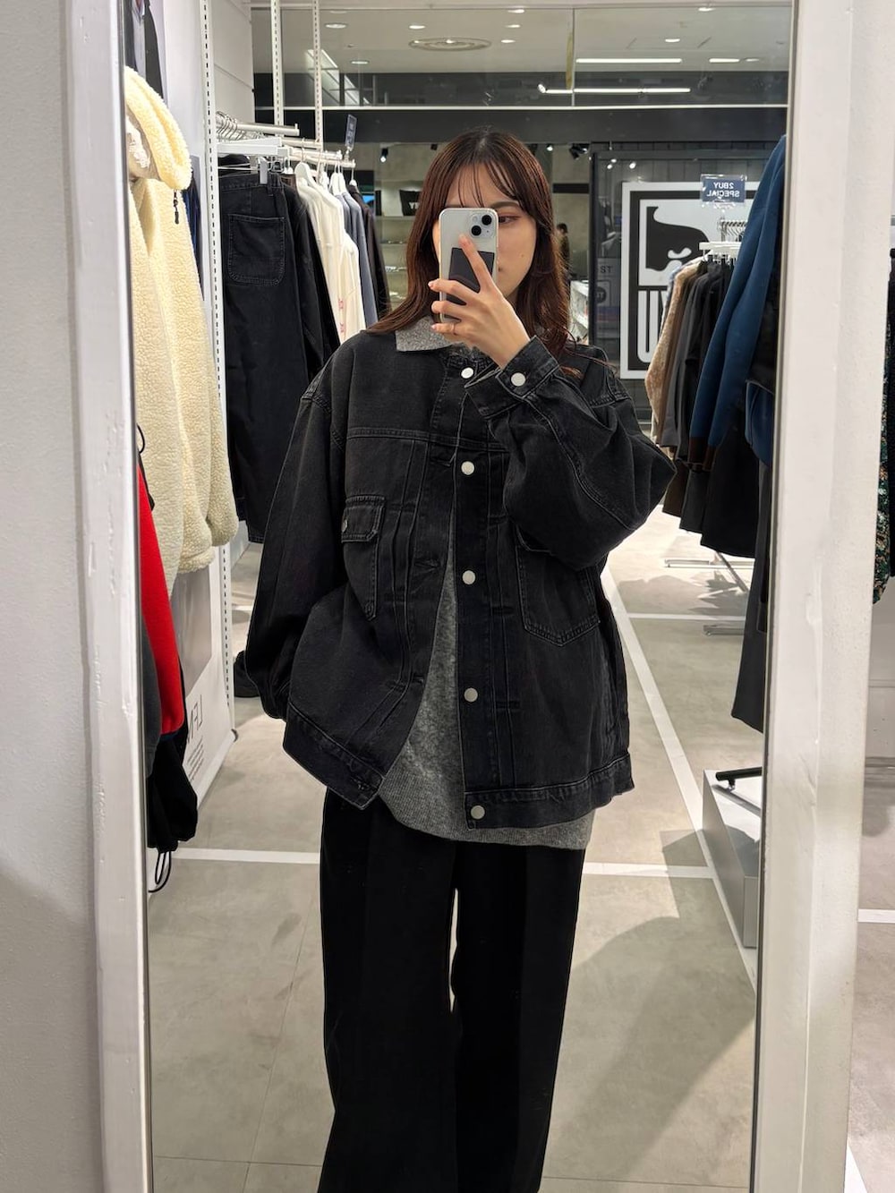 ブラック系のデニムジャケット、グレー系のニット/セーターを着用したレディースの秋コーディネートの2枚目の写真