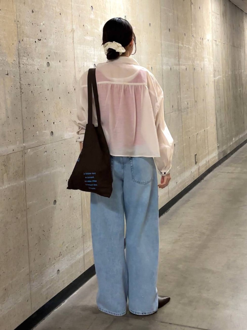 ブルー系のデニムパンツ、ホワイト系のシャツ/ブラウス、ブラウン系のトートバッグを着用したレディースの春コーディネートの3枚目の写真