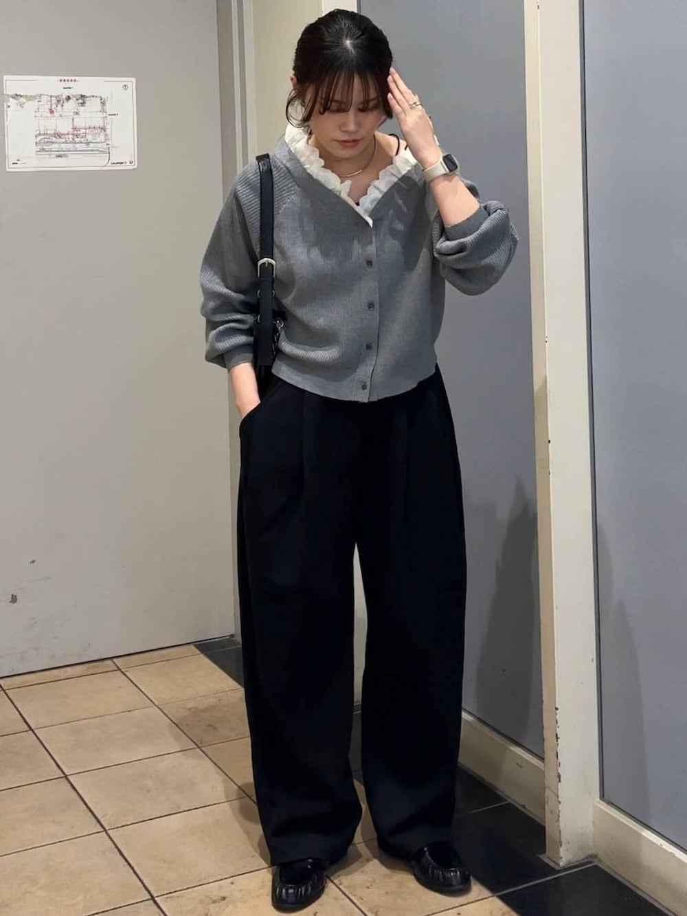 ブラック系のスウェットパンツ、ブラック系のショルダーバッグ、ブラック系のローファーを着用したレディースの春コーディネートの6枚目の写真