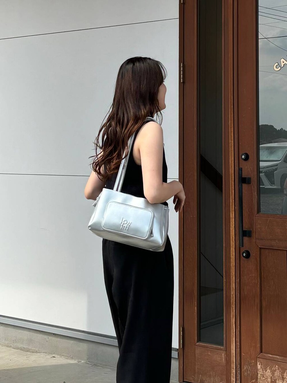 ブラック系のタンクトップ、ブラック系のスニーカー、ブラック系のスラックスを着用したレディースの夏コーディネートの3枚目の写真