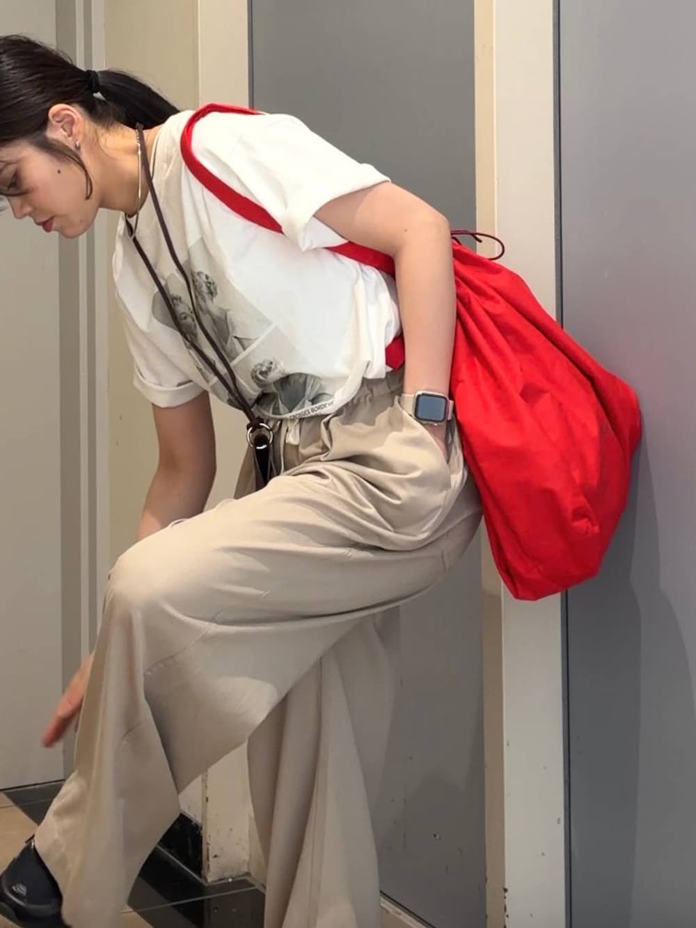 ベージュ系のデニムパンツ、レッド系のショルダーバッグ、ホワイト系のTシャツ/カットソーを着用したレディースの春コーディネートの6枚目の写真