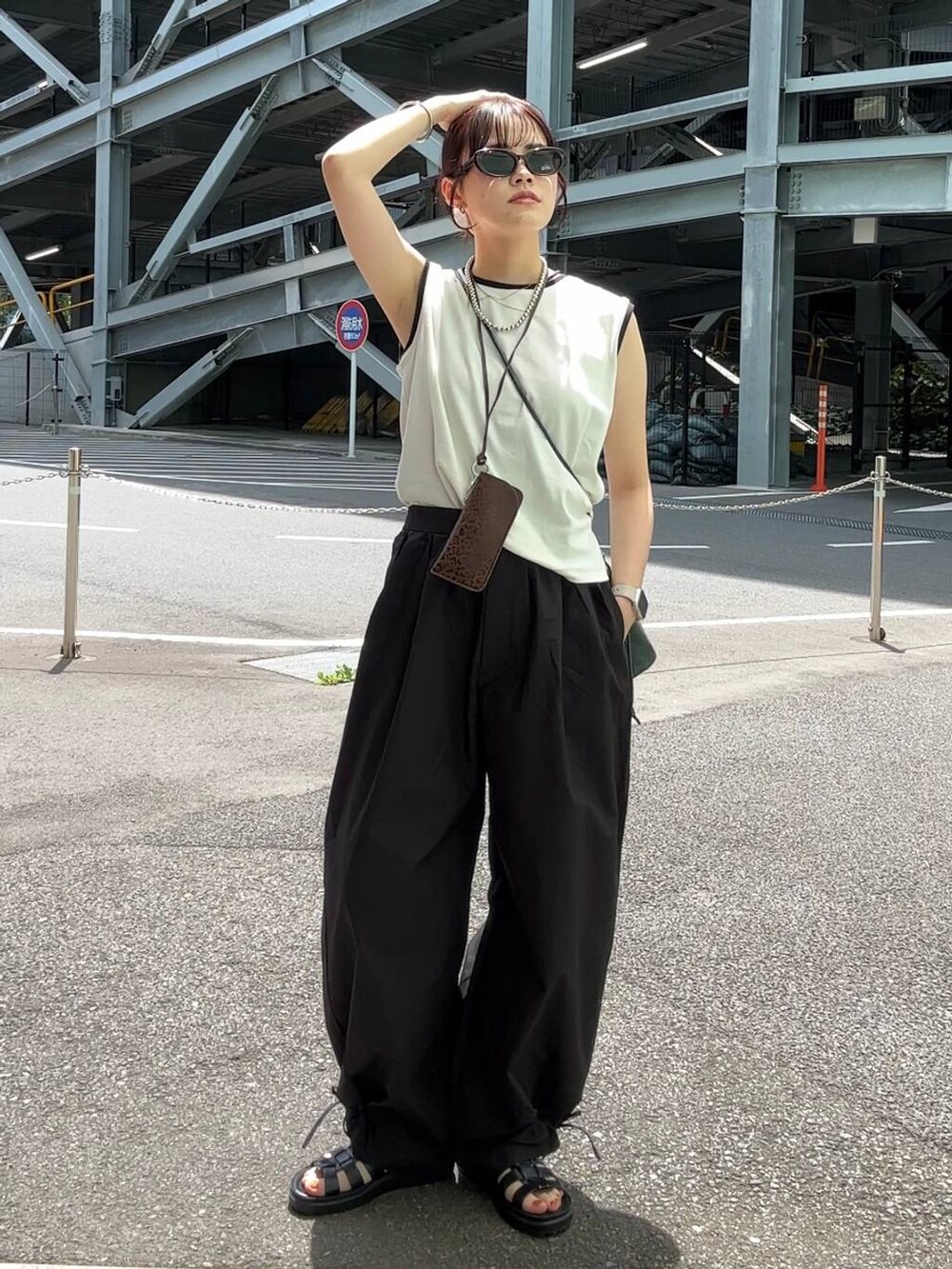 ブラック系のサンダル、グリーン系のショルダーバッグ、ブラック系のその他パンツを着用したレディースの夏コーディネートの2枚目の写真