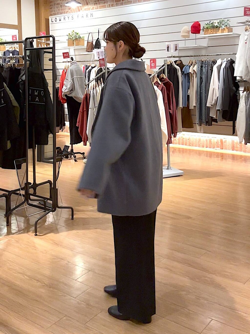 レッド系のニット/セーター、ブラック系のブーツ、ブラック系のその他パンツを着用したレディースの冬コーディネートの3枚目の写真