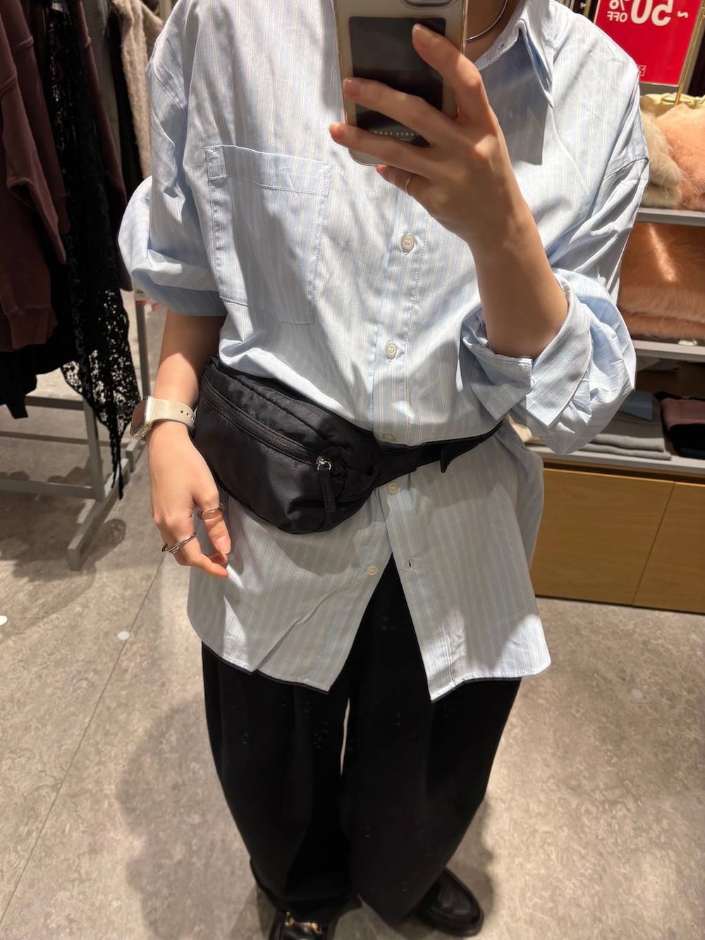 ブラック系のスウェットパンツ、ブラック系のボディバッグ/ウエストポーチ、ブルー系のシャツ/ブラウスを着用したレディースの冬コーディネートの2枚目の写真