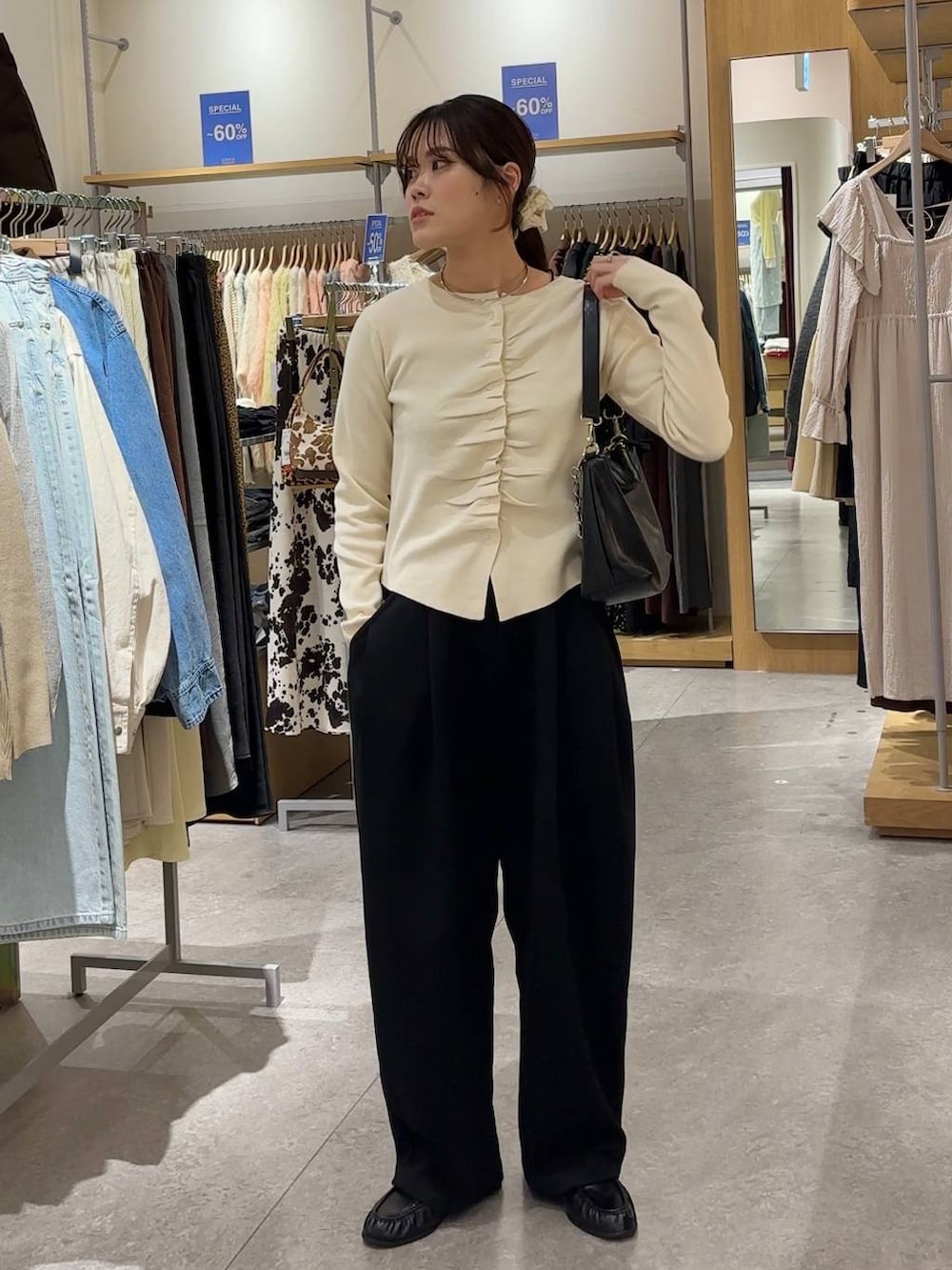 ブラック系のスウェットパンツ、ブラック系のショルダーバッグ、ブラック系のローファーを着用したレディースの春コーディネートの5枚目の写真