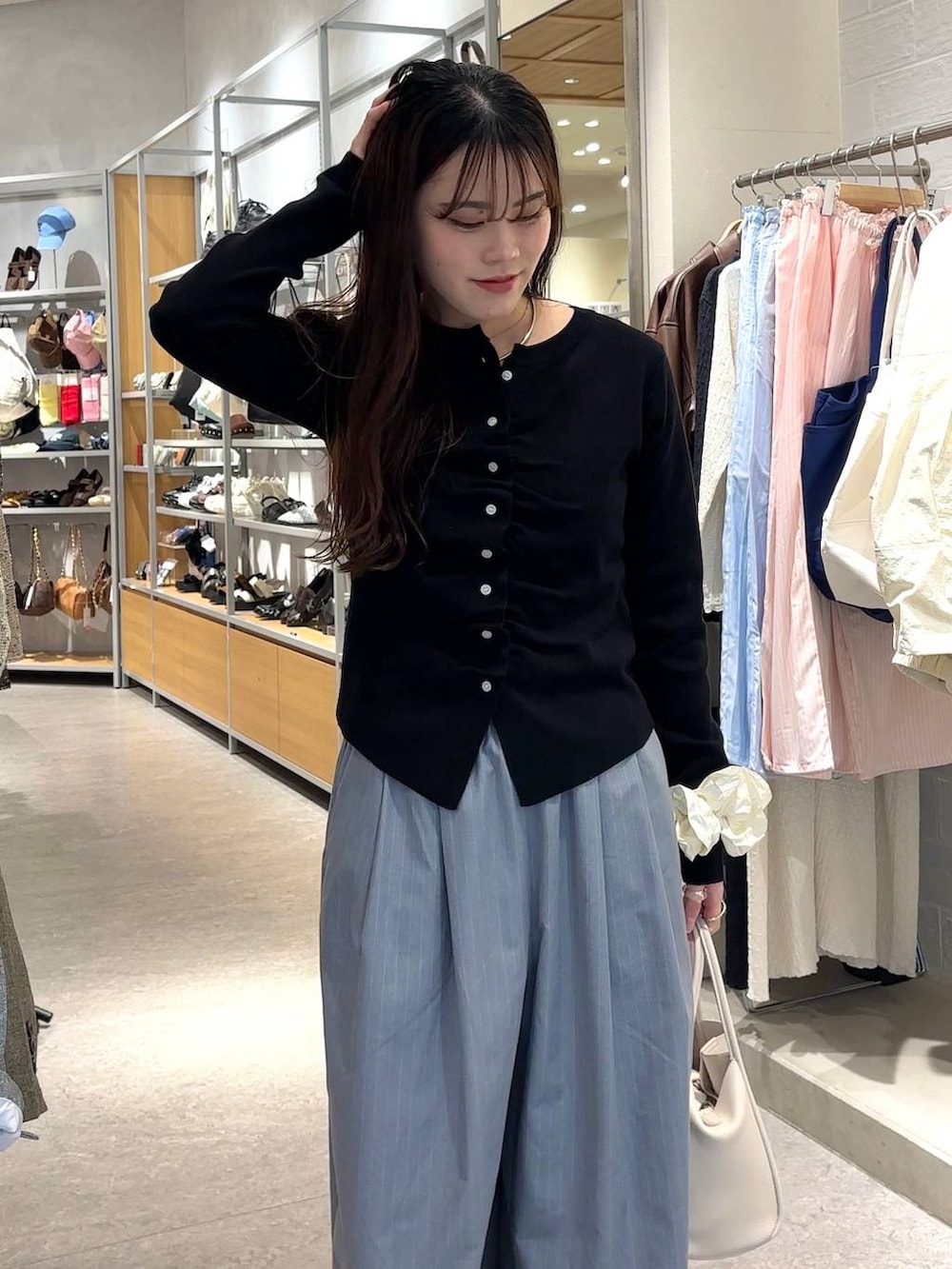 グレー系のその他パンツ、ホワイト系のショルダーバッグ、ブラック系のカーディガン/ボレロを着用したレディースの春コーディネートの4枚目の写真