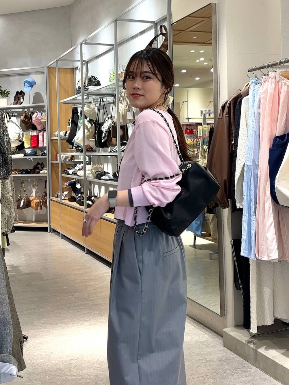 シルバー系のタンクトップ、グレー系のその他パンツ、ブラック系のショルダーバッグを着用したレディースの春コーディネートの6枚目の写真