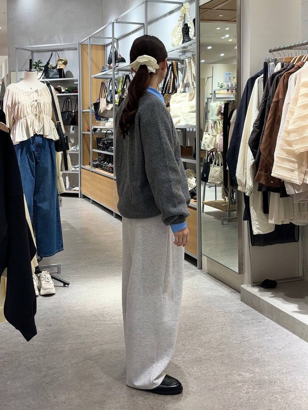 グレー系のスウェットパンツ、ブルー系のシャツ/ブラウス、ブラック系のローファーを着用したレディースの秋コーディネートの2枚目の写真