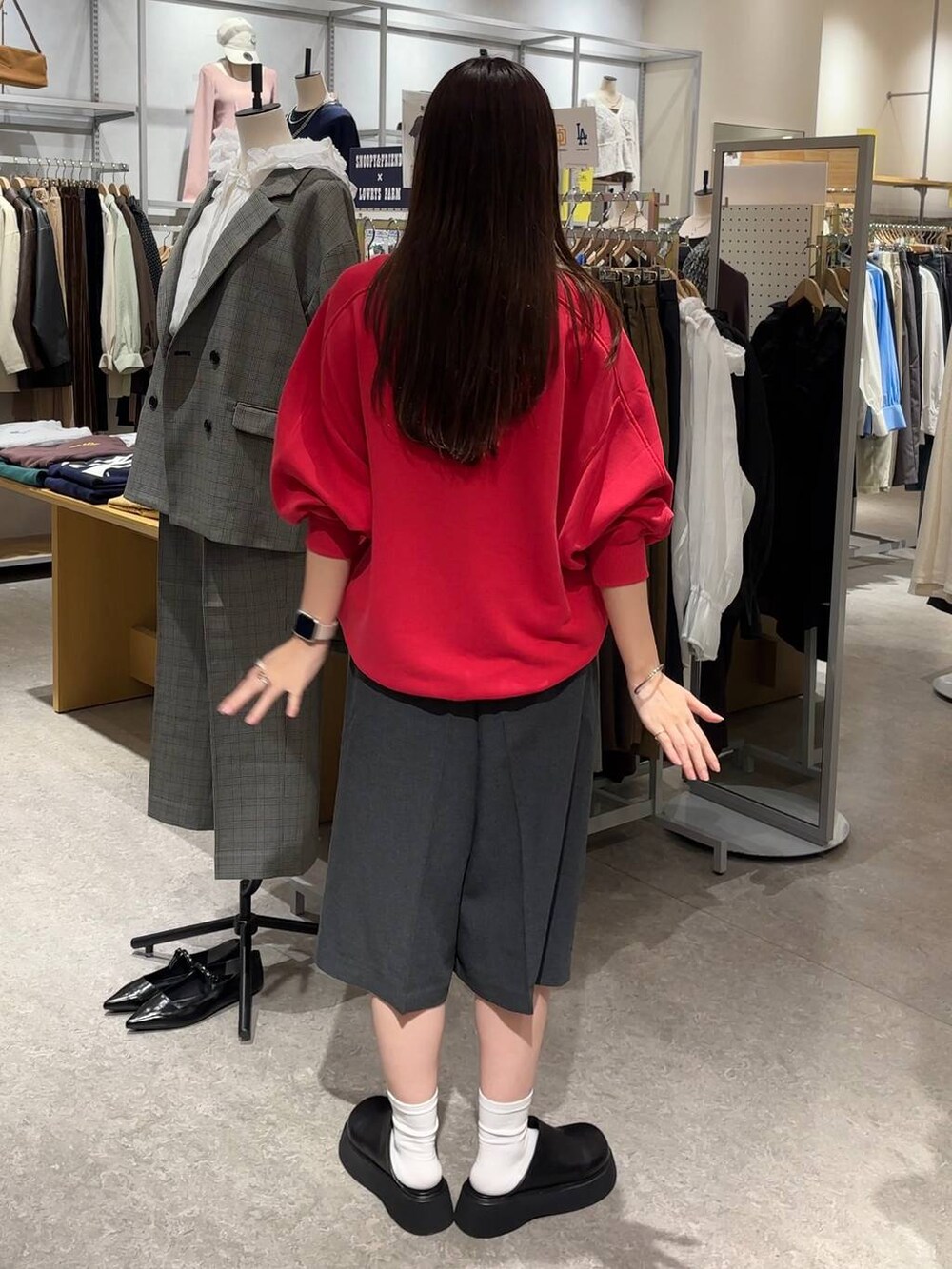 グレー系のその他パンツ、ブラック系のサンダル、レッド系のスウェットを着用したレディースの秋コーディネートの4枚目の写真