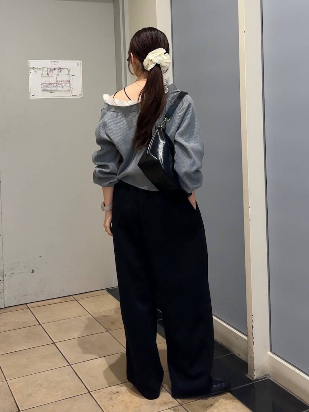 ブラック系のスウェットパンツ、ブラック系のショルダーバッグ、ブラック系のローファーを着用したレディースの春コーディネートの3枚目の写真