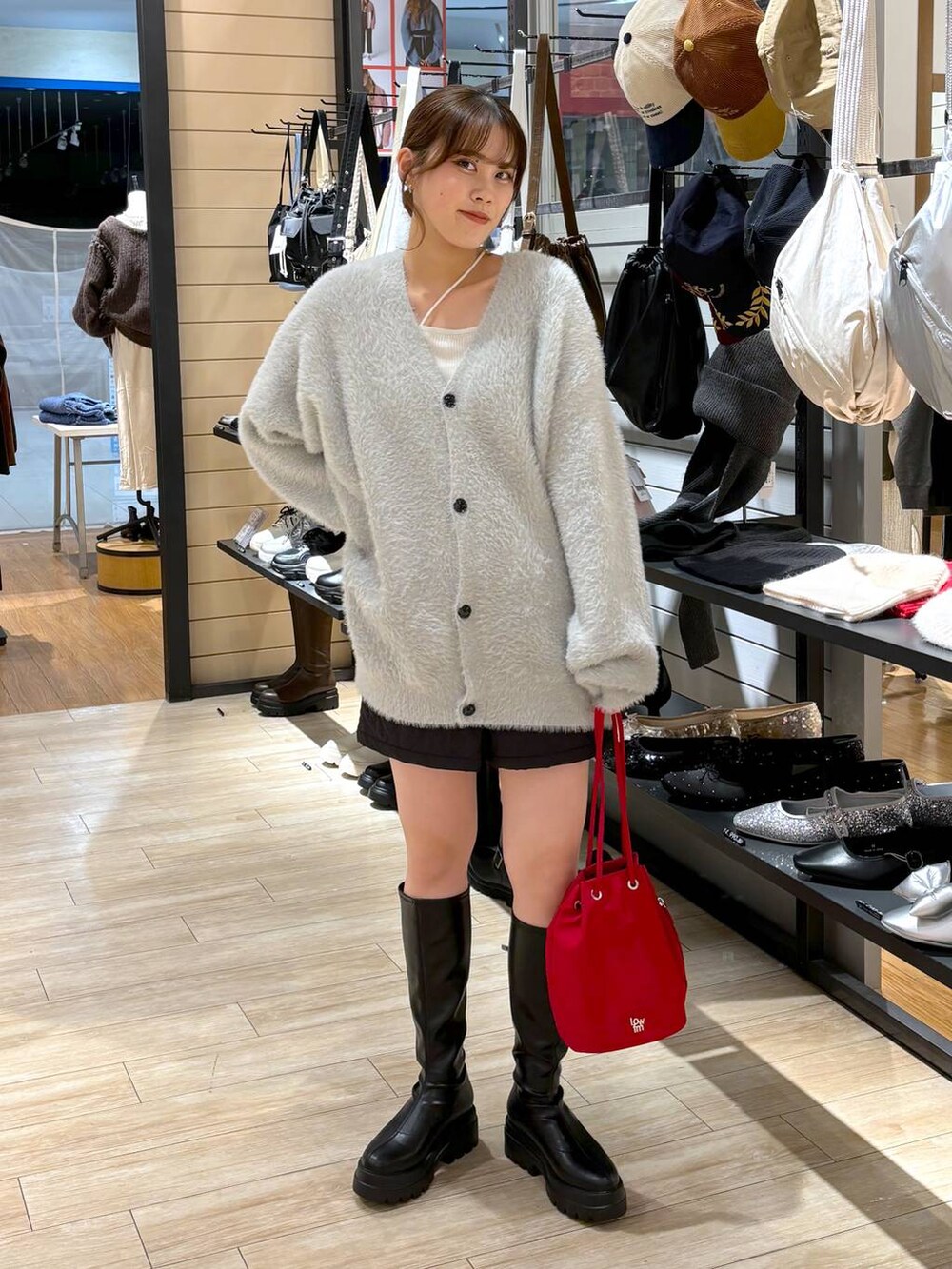 ブラック系のその他パンツ、ホワイト系のキャミソール、ブラック系のブーツを着用したレディースの冬コーディネートの2枚目の写真