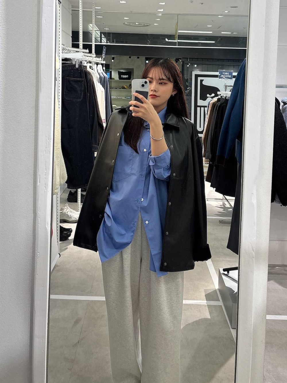 グレー系のスウェットパンツ、ブルー系のシャツ/ブラウス、ブラック系のライダースジャケットを着用したレディースの秋コーディネートの2枚目の写真