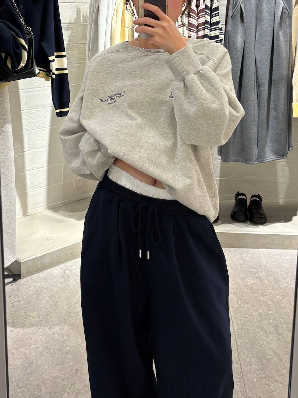 ブラック系のローファー、グレー系のスウェット、ブルー系のスウェットパンツを着用したレディースの冬コーディネートの2枚目の写真