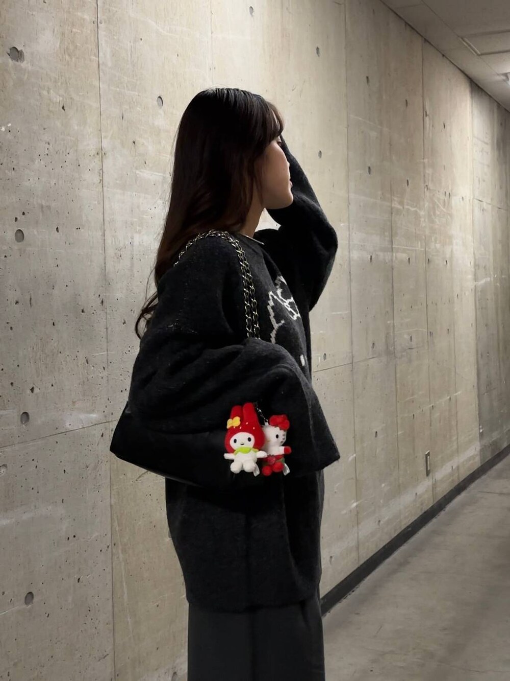 グレー系のニット/セーター、ブラック系のショルダーバッグを着用したレディースの秋コーディネートの3枚目の写真