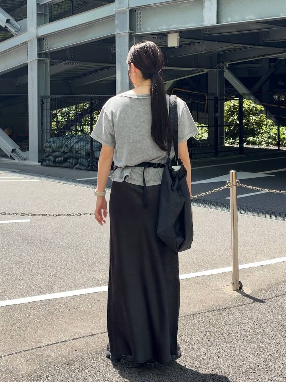 ブラック系のスカート、ブラック系のショルダーバッグ、グレー系のTシャツ/カットソーを着用したレディースの春コーディネートの3枚目の写真