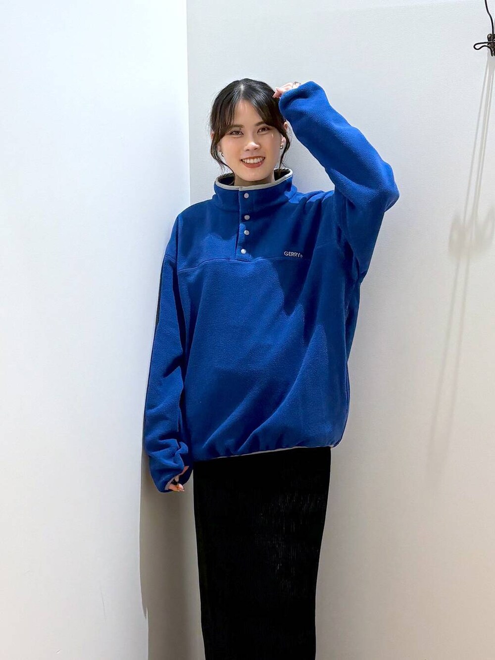 ブラック系のスカート、ブルー系のTシャツ/カットソー、ブラック系のスニーカーを着用したレディースの秋コーディネートの2枚目の写真