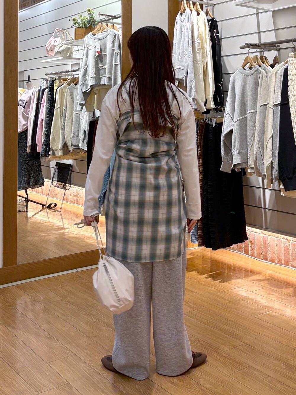 ホワイト系のTシャツ/カットソー、ホワイト系のショルダーバッグ、グリーン系のシャツ/ブラウスを着用したレディースの冬コーディネートの5枚目の写真