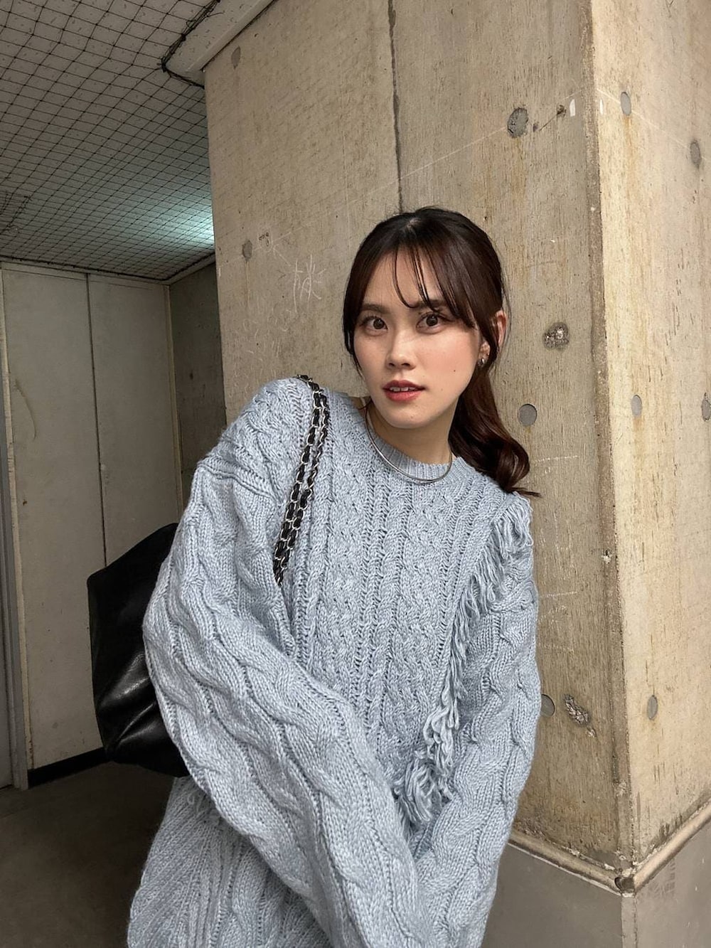 ブルー系のニット/セーター、ブラック系のショルダーバッグ、シルバー系のチョーカーを着用したレディースの秋コーディネートの3枚目の写真