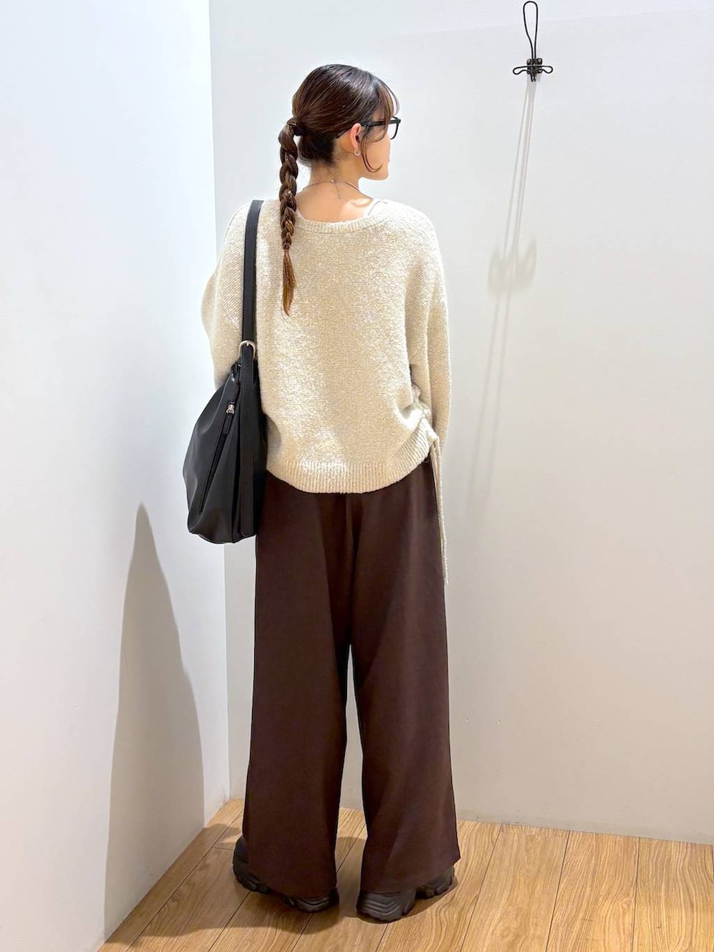 ブラック系のブーツ、ブラック系のショルダーバッグ、ブラウン系のその他パンツを着用したレディースの冬コーディネートの4枚目の写真