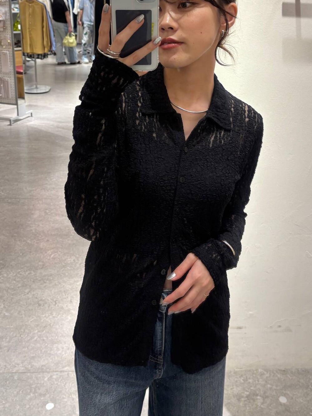 ブルー系のデニムパンツ、ブラック系のショルダーバッグ、ブラック系のキャミソールを着用したレディースの秋コーディネートの5枚目の写真