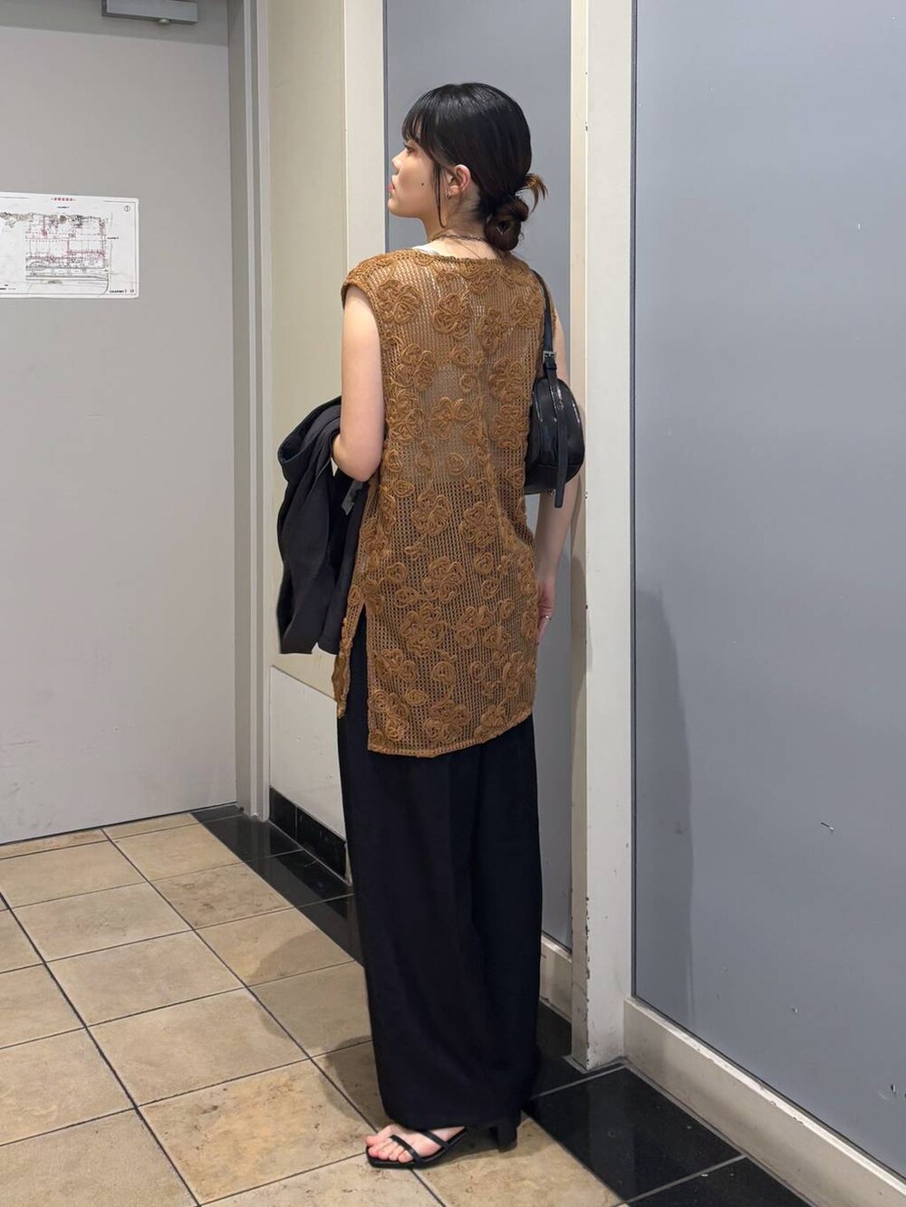 ホワイト系のTシャツ/カットソー、ブラック系のトートバッグ、ブラック系のサンダルを着用したレディースの春コーディネートの3枚目の写真