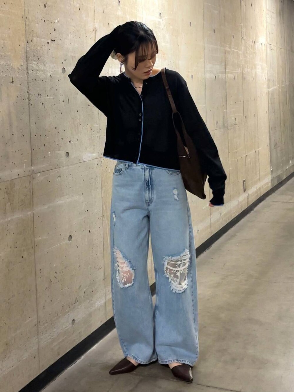 ブルー系のデニムパンツ、ブラウン系のショルダーバッグ、ブラック系のカーディガン/ボレロを着用したレディースの春コーディネートの8枚目の写真