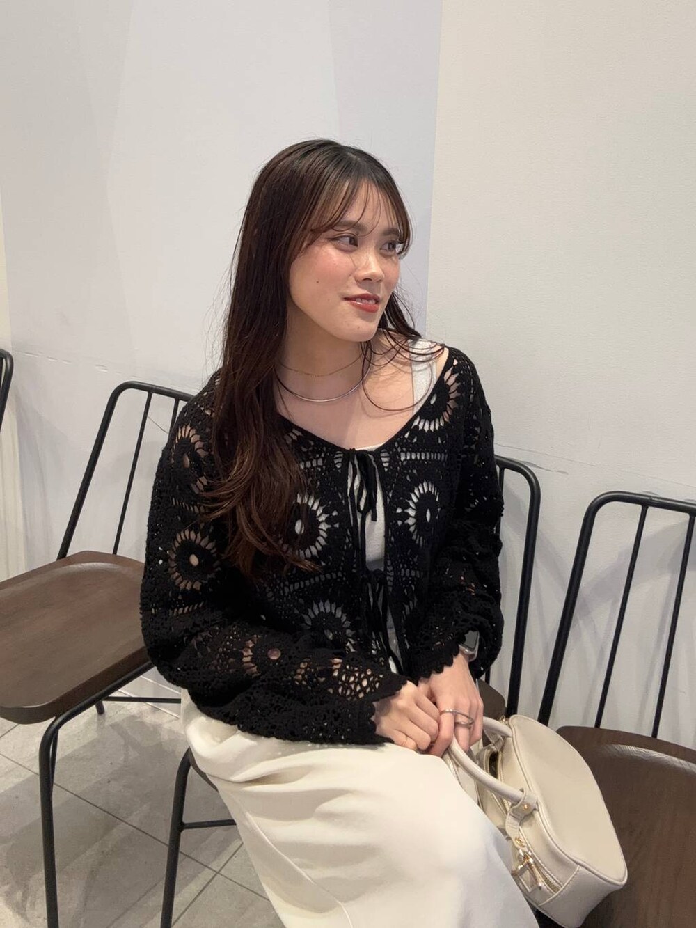 シルバー系のタンクトップ、ホワイト系のボストンバッグ、ホワイト系のその他パンツを着用したレディースの春コーディネートの3枚目の写真