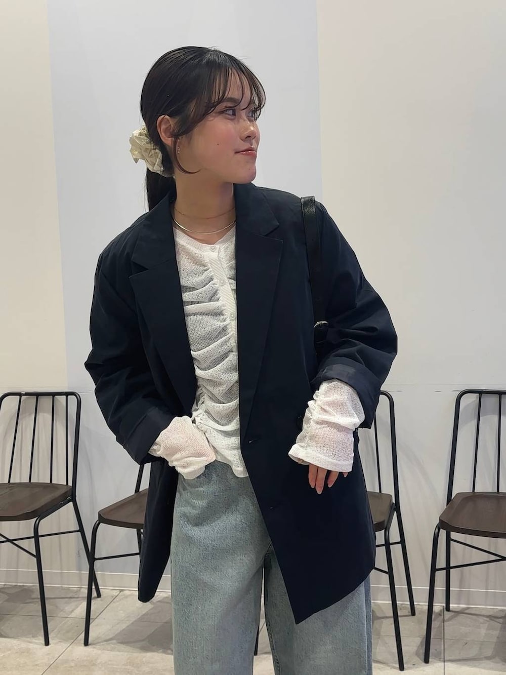 ブルー系のデニムパンツ、ブラック系のショルダーバッグ、ブラック系のローファーを着用したレディースの春コーディネートの2枚目の写真