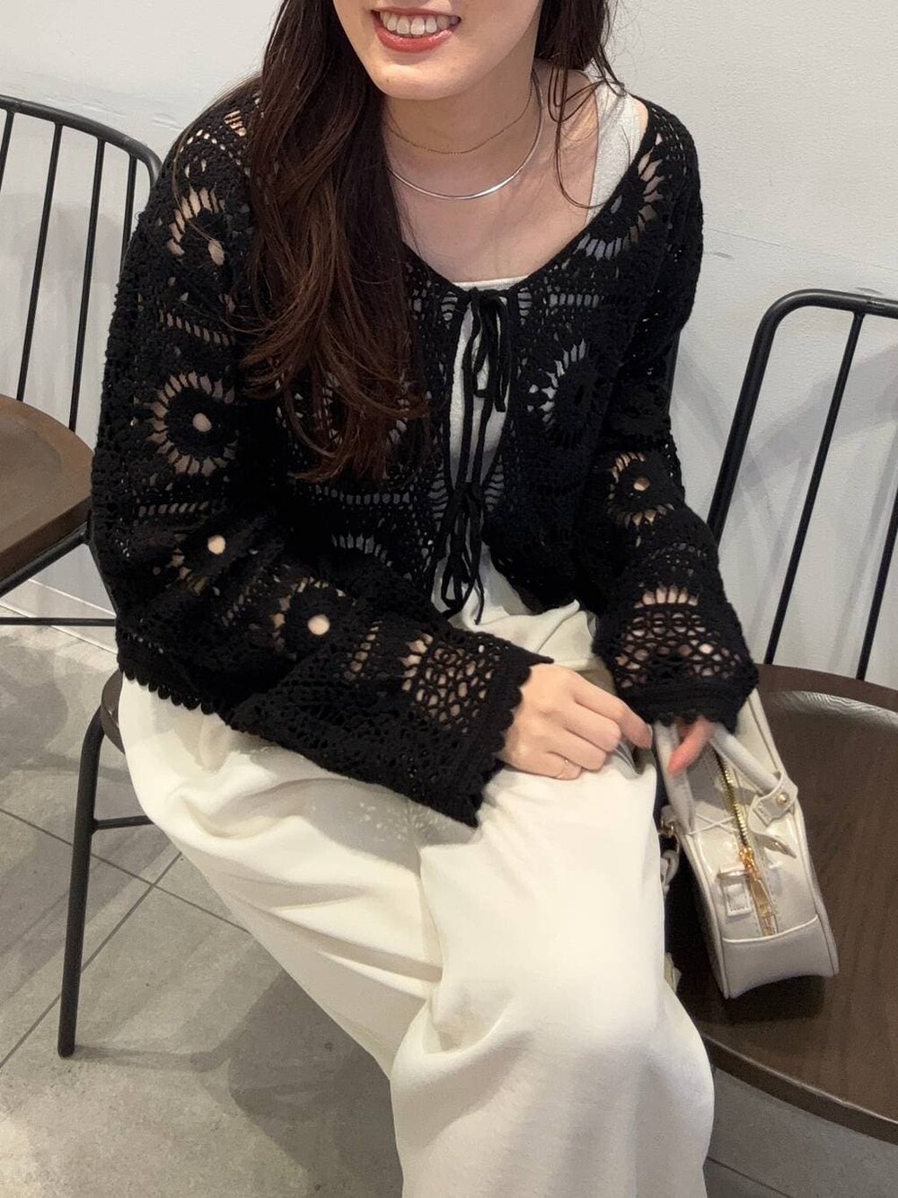 シルバー系のタンクトップ、ホワイト系のボストンバッグ、ホワイト系のその他パンツを着用したレディースの春コーディネートの4枚目の写真