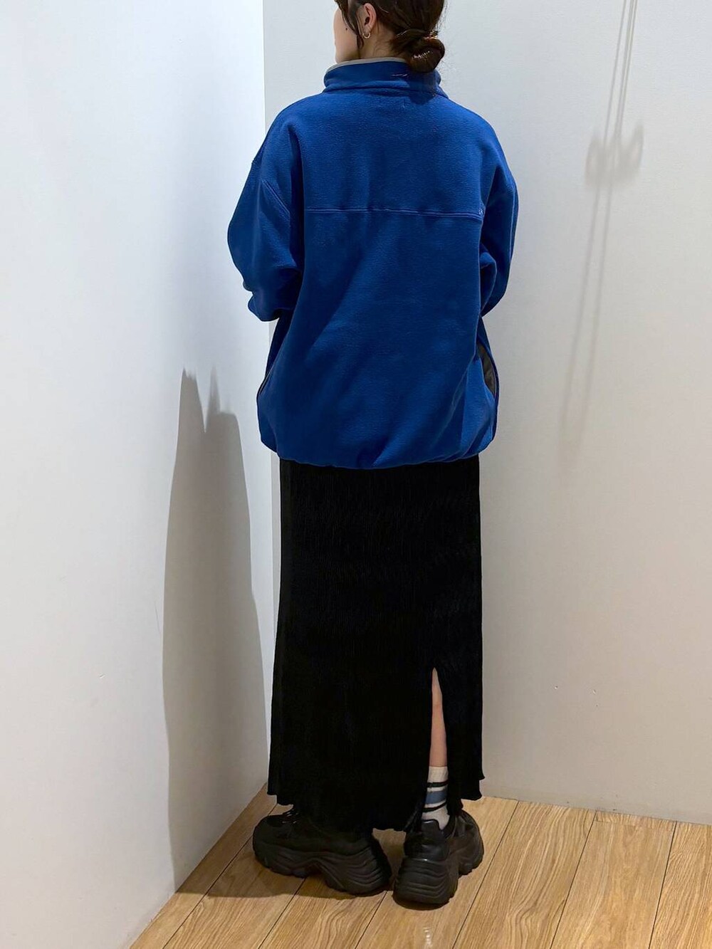 ブラック系のスカート、ブルー系のTシャツ/カットソー、ブラック系のスニーカーを着用したレディースの秋コーディネートの4枚目の写真