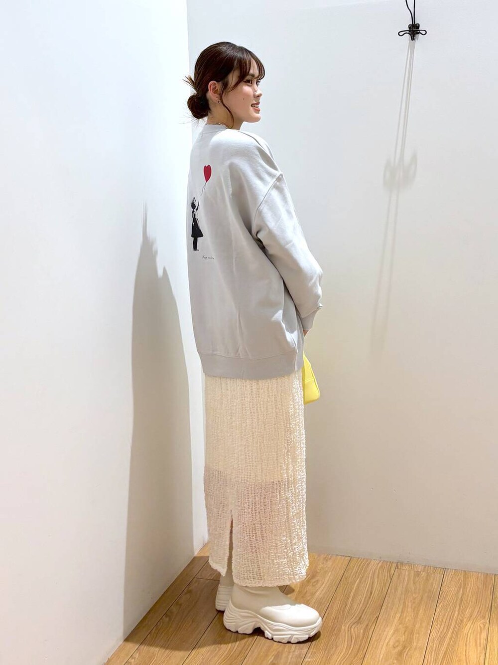 ホワイト系のブーツ、イエロー系のボストンバッグ、グレー系のTシャツ/カットソーを着用したレディースの秋コーディネートの2枚目の写真