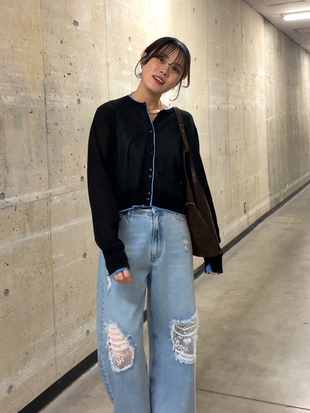 ブルー系のデニムパンツ、ブラウン系のショルダーバッグ、ブラック系のカーディガン/ボレロを着用したレディースの春コーディネートの6枚目の写真