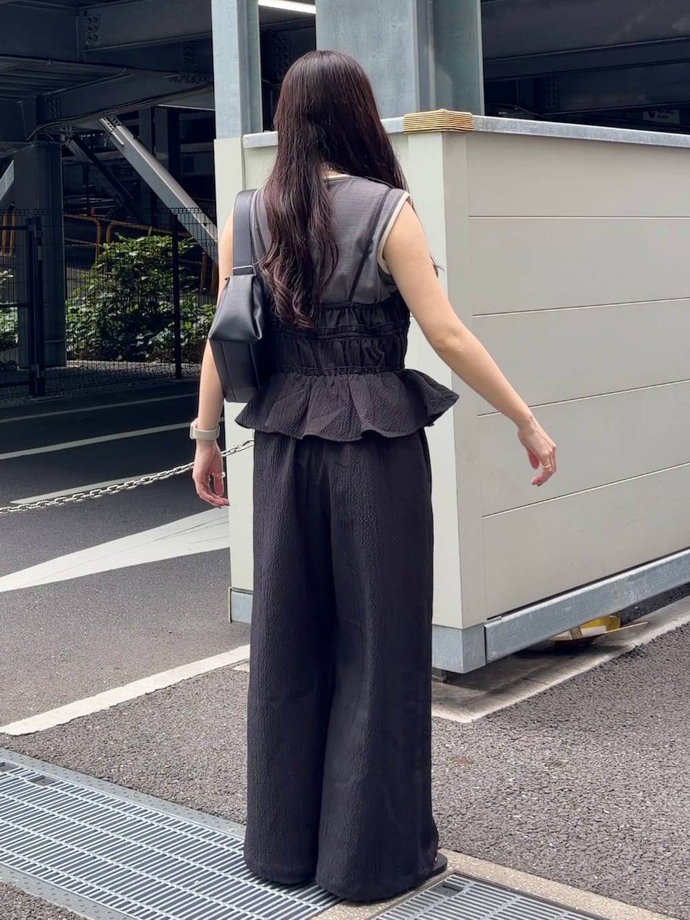 グレー系のタンクトップ、ブラック系のサンダル、ブラック系のショルダーバッグを着用したレディースの春コーディネートの3枚目の写真