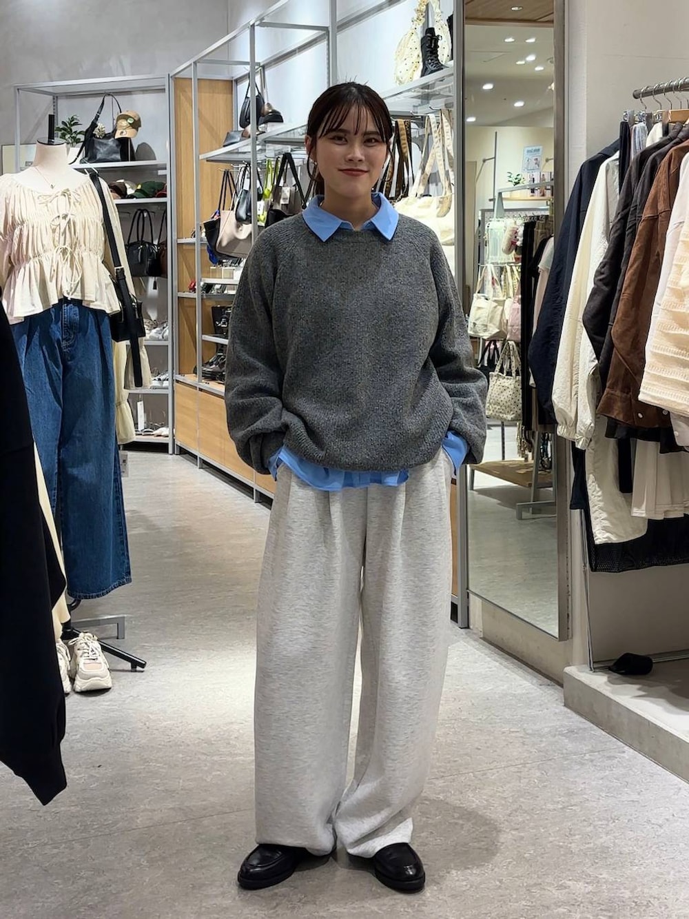 グレー系のスウェットパンツ、ブルー系のシャツ/ブラウス、ブラック系のローファーを着用したレディースの秋コーディネートの3枚目の写真