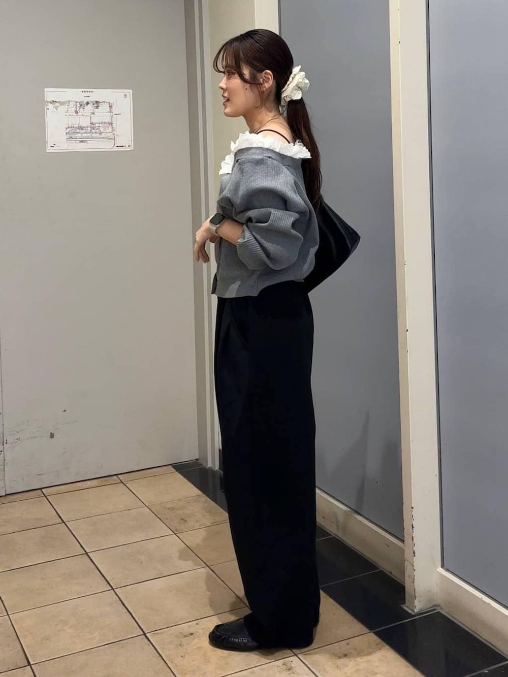 ブラック系のスウェットパンツ、ブラック系のショルダーバッグ、ブラック系のローファーを着用したレディースの春コーディネートの2枚目の写真