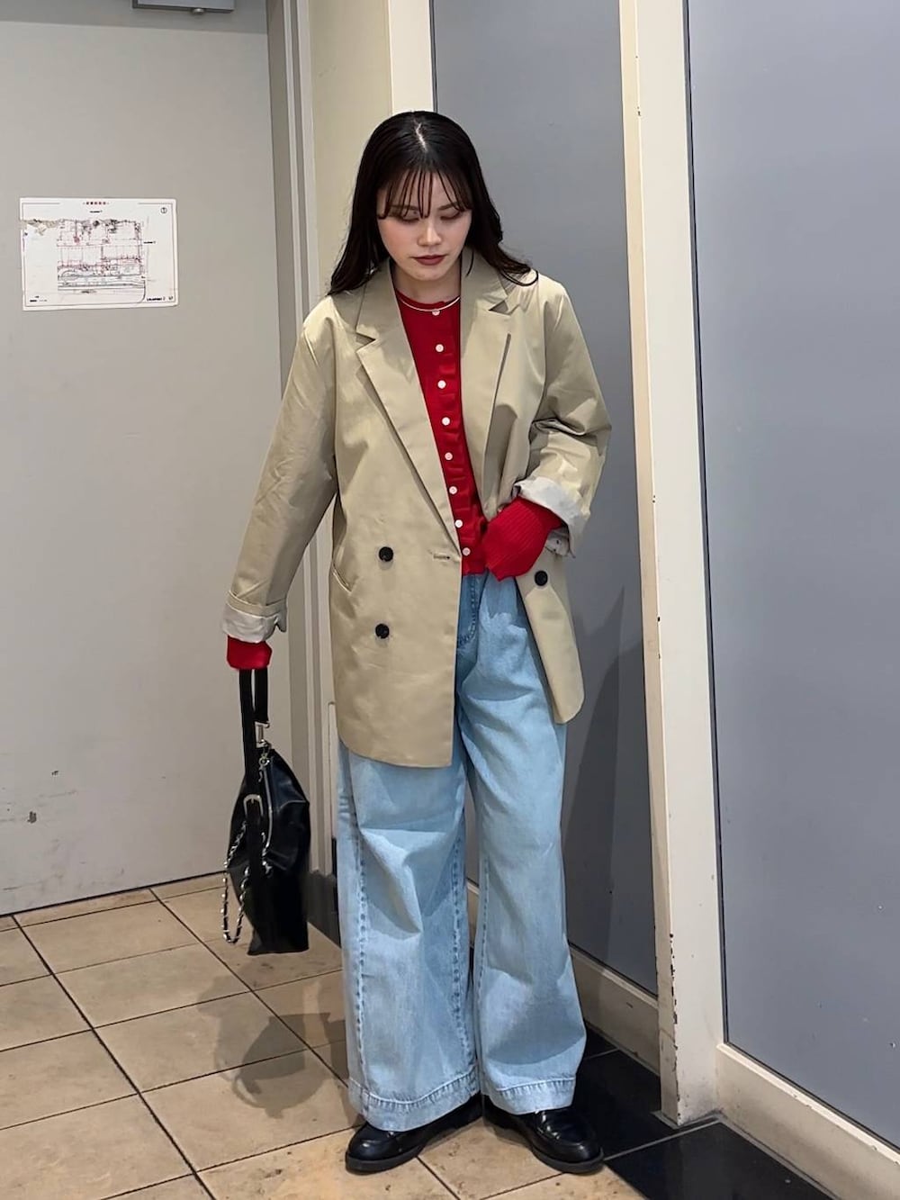 ブラック系のローファー、ブルー系のデニムパンツ、ブラック系のショルダーバッグを着用したレディースの冬コーディネートの4枚目の写真