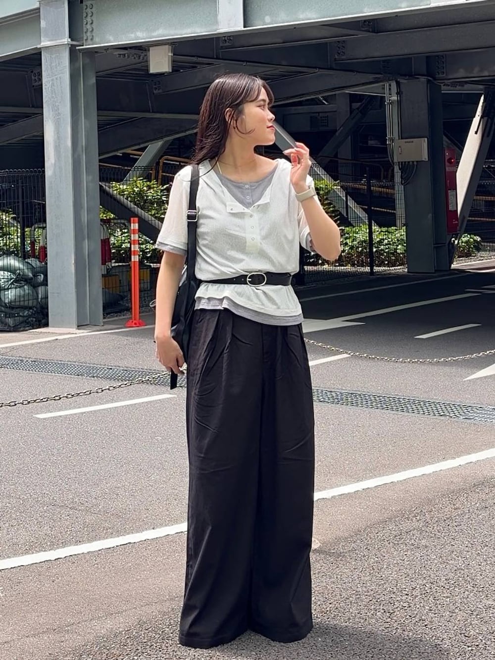 ブラック系のスラックス、シルバー系のサンダル、ホワイト系のTシャツ/カットソーを着用したレディースの春コーディネートの5枚目の写真