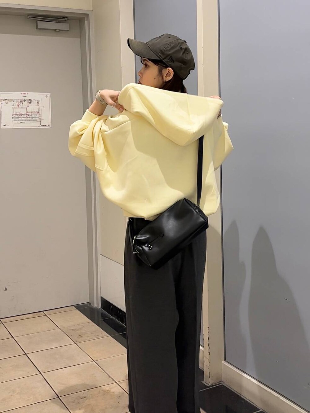 グレー系のサロペット/オーバーオール、ブラック系のショルダーバッグ、ブラック系のキャミソールを着用したレディースの秋コーディネートの5枚目の写真