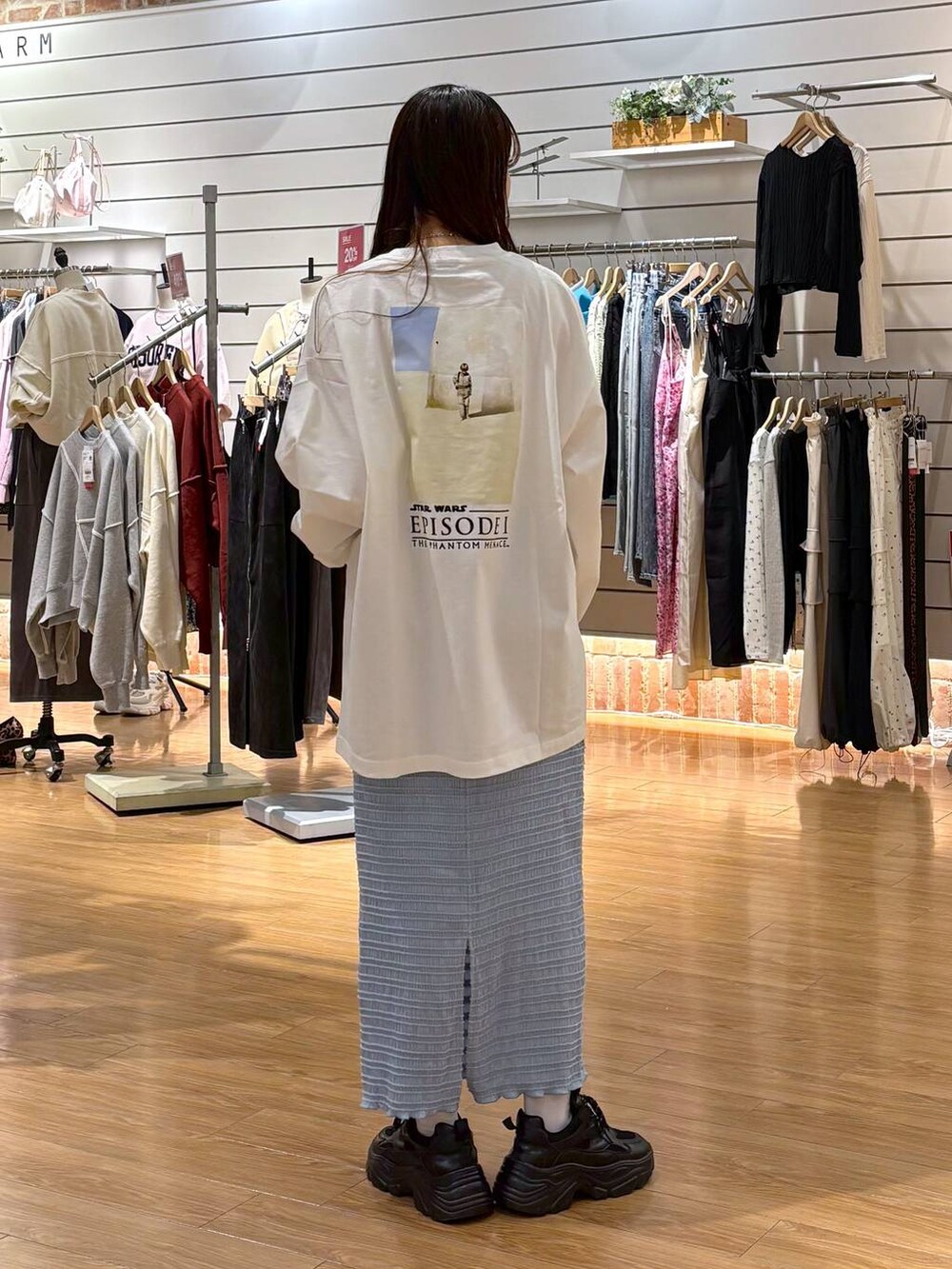 ブラック系のスニーカー、ホワイト系のTシャツ/カットソー、ブルー系のスカートを着用したレディースの冬コーディネートの2枚目の写真