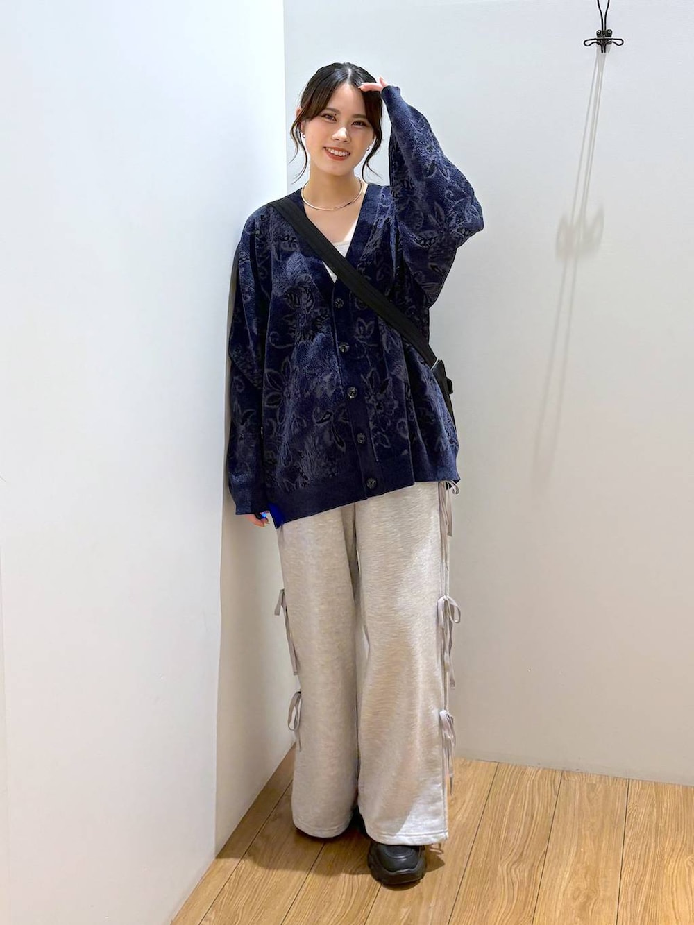 ブラック系のスニーカー、ブラック系のショルダーバッグ、グレー系のスウェットパンツを着用したレディースの秋コーディネートの2枚目の写真