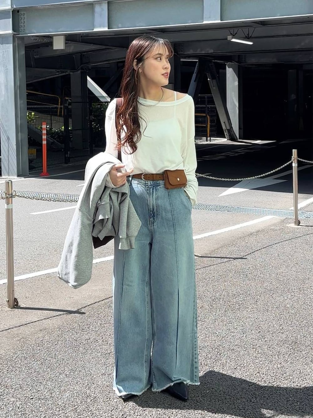 ホワイト系のTシャツ/カットソー、ブラウン系のトートバッグ、ブルー系のデニムパンツを着用したレディースの春コーディネートの2枚目の写真