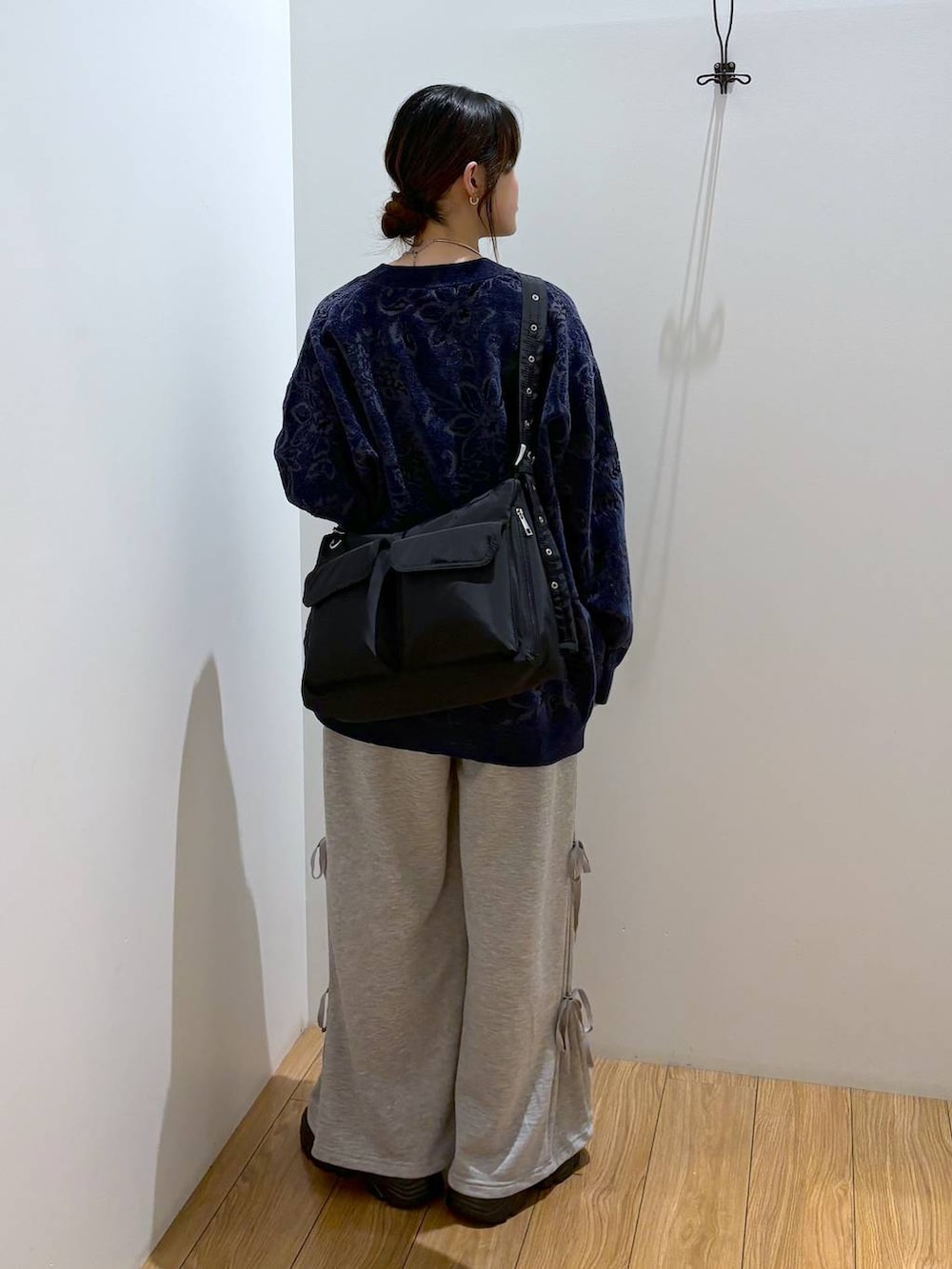 ブラック系のスニーカー、ブラック系のショルダーバッグ、グレー系のスウェットパンツを着用したレディースの秋コーディネートの4枚目の写真