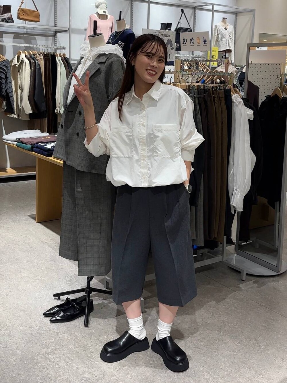 グレー系のその他パンツ、ブラック系のサンダル、ホワイト系のシャツ/ブラウスを着用したレディースの秋コーディネートの2枚目の写真