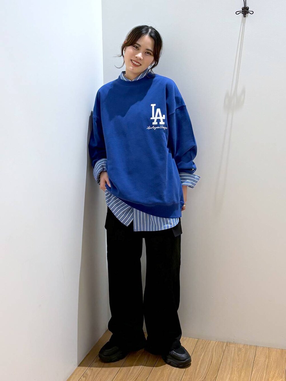 ブルー系のシャツ/ブラウス、ブラック系のスラックス、ブラック系のスニーカーを着用したレディースの秋コーディネートの5枚目の写真