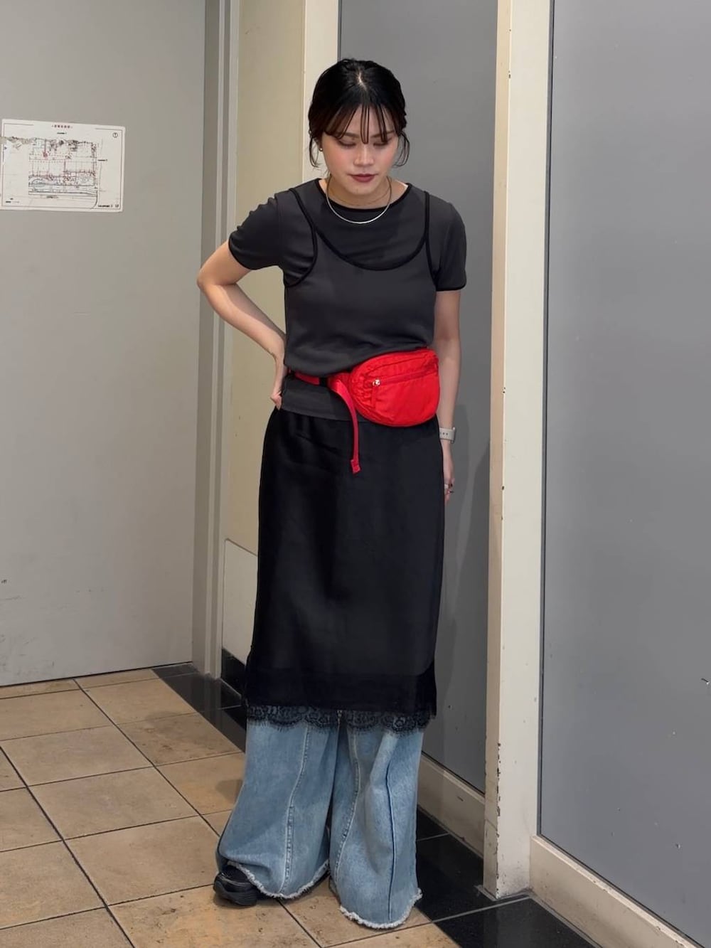 ブルー系のデニムパンツ、レッド系のボディバッグ/ウエストポーチ、ブラック系のスカートを着用したレディースの春コーディネートの5枚目の写真