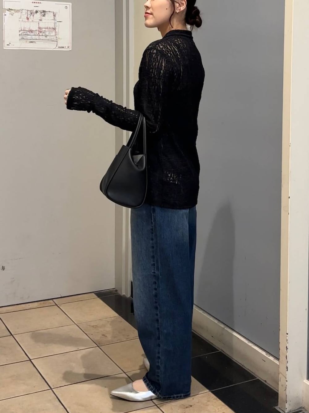 ブルー系のデニムパンツ、ブラック系のショルダーバッグ、ブラック系のキャミソールを着用したレディースの秋コーディネートの2枚目の写真