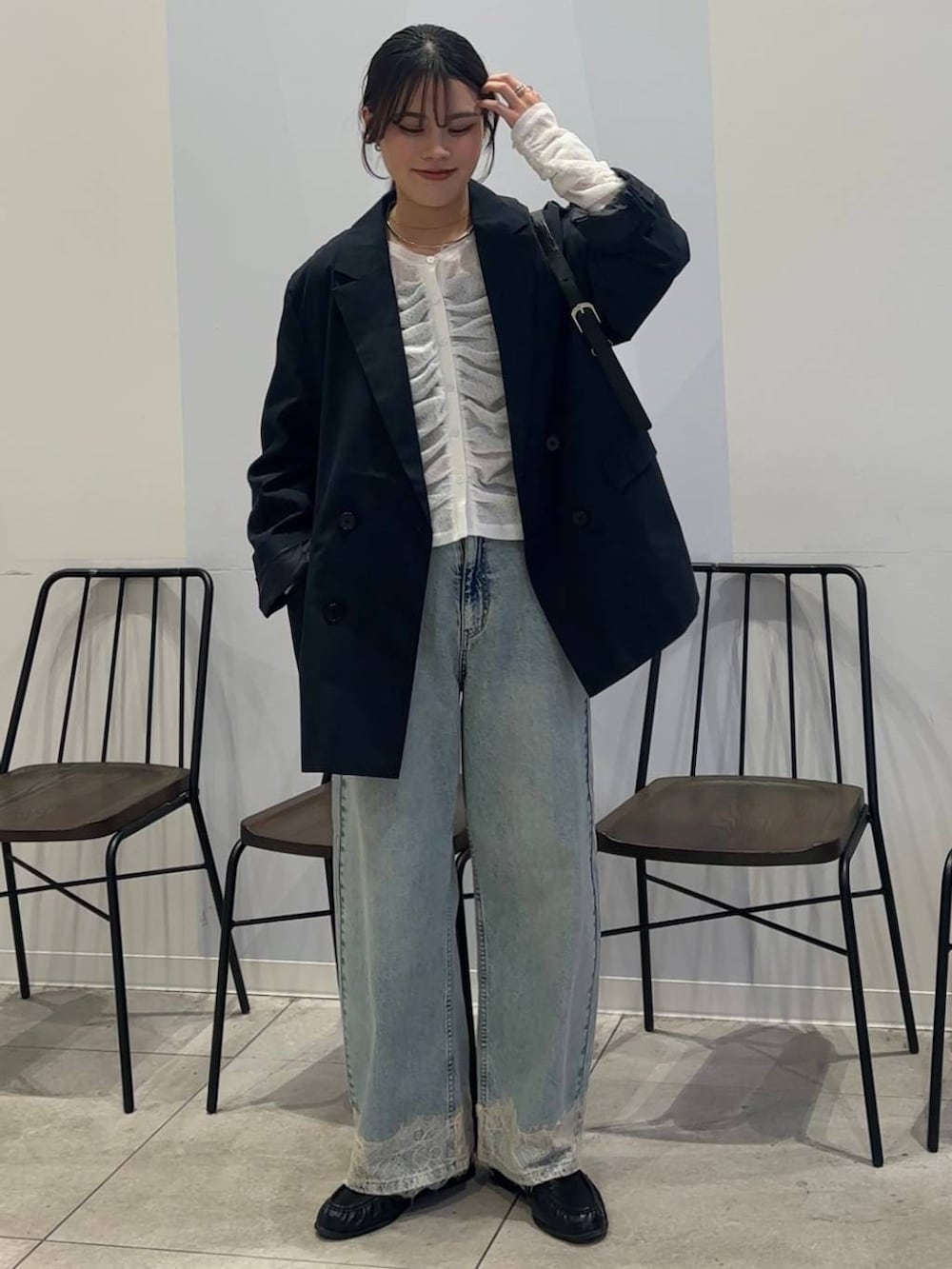 ブルー系のデニムパンツ、ブラック系のショルダーバッグ、ブラック系のローファーを着用したレディースの春コーディネートの8枚目の写真