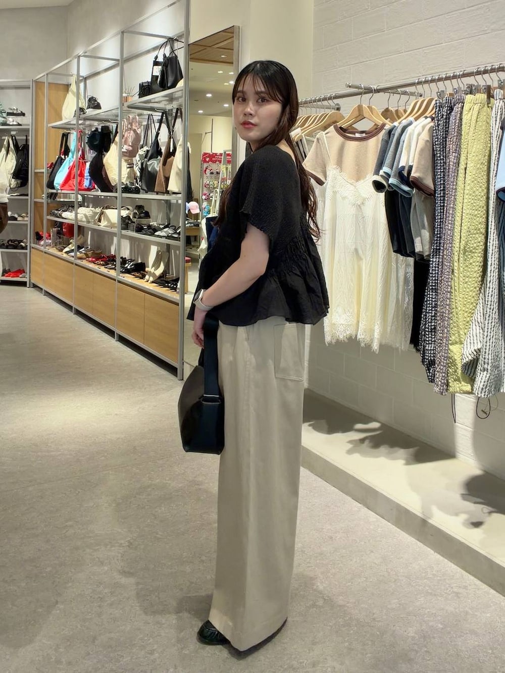 ゴールド系のタンクトップ、ベージュ系のデニムパンツ、ブラック系のローファーを着用したレディースの春コーディネートの2枚目の写真