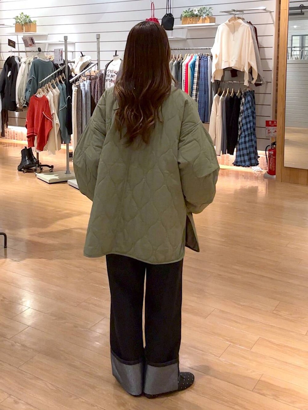 グリーン系のブルゾン、ブラック系のバレエシューズ、ブラック系のデニムパンツを着用したレディースの冬コーディネートの4枚目の写真